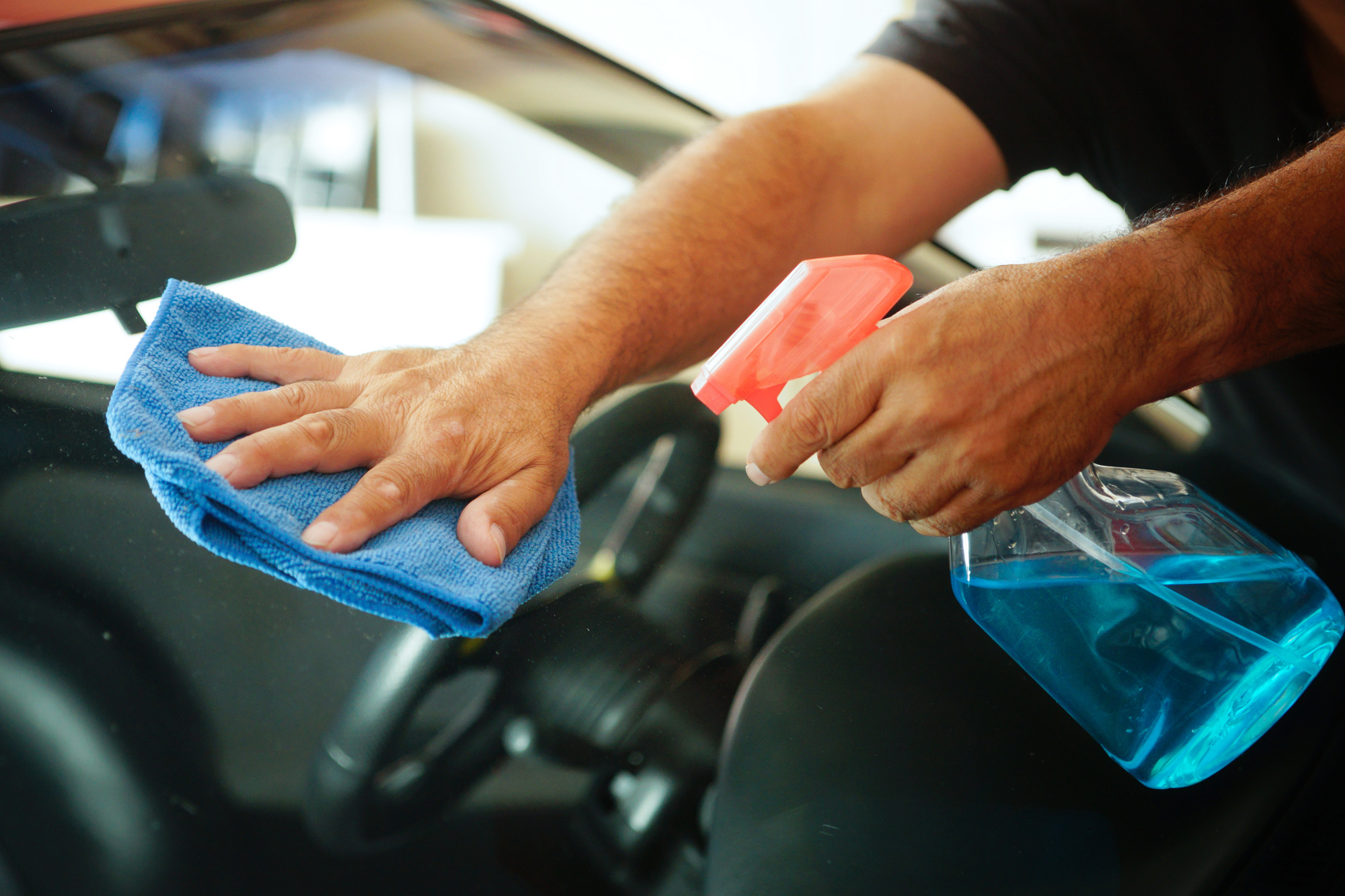 photo of a hand holding a towel and wiping down a car window