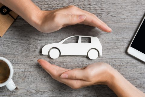 hands protecting cutout of white car