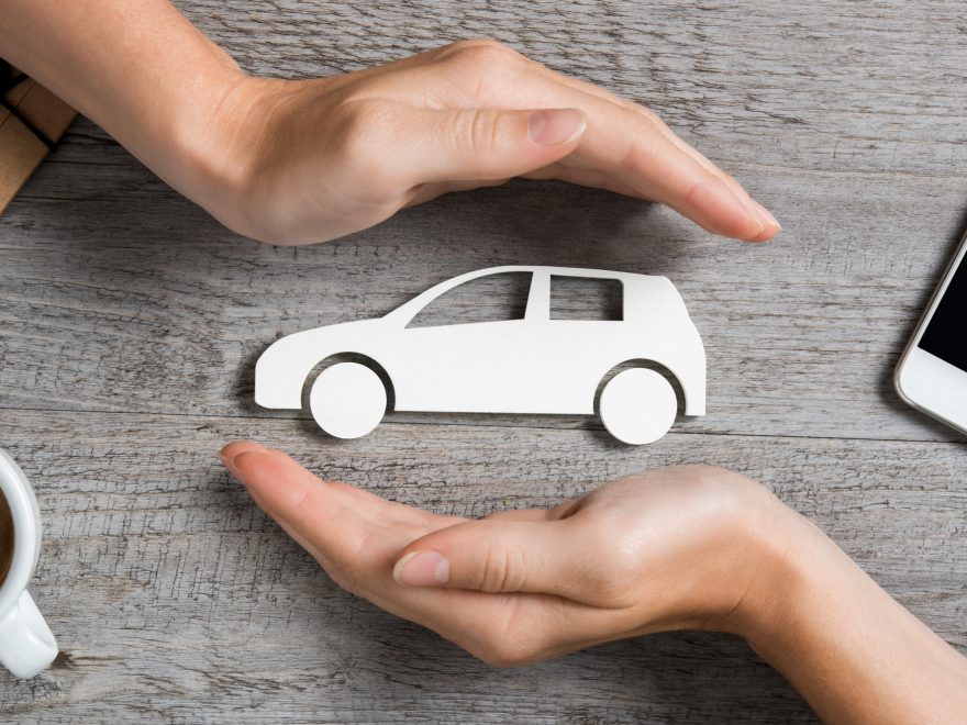 hands protecting cutout of white car